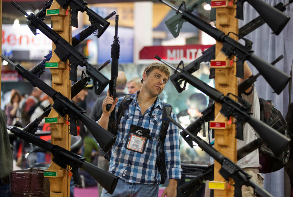 A man checks out a display of rifles at the Rock River Arms booth during the 35th annual SHOT Show on Thursday, January 17, 2013, in Las Vegas.