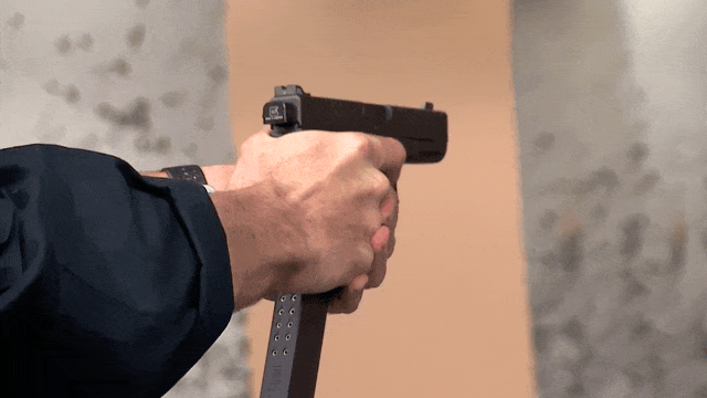 An ATF agent fires a Glock equipped with a switch and extended magazine