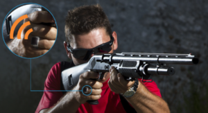 A man aims an iGun M-2000 shotgun while wearing the correct RFID-enabled ring.