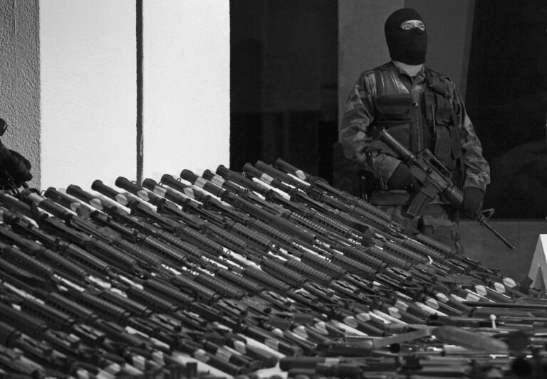 A soldier stands guard over firearms captured from the Gulf Cartel in Mexico.