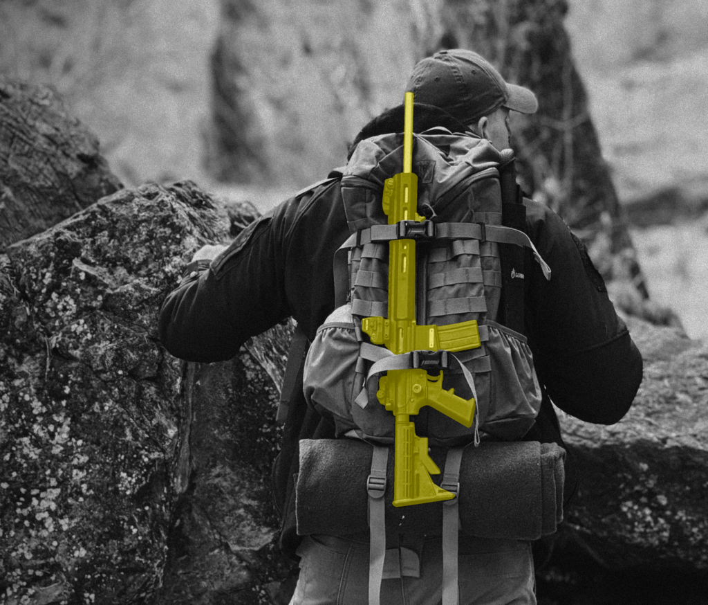 A stylized image showing a man carrying a Mountain Billy Gun Lab GOAT-15 in the wilderness.