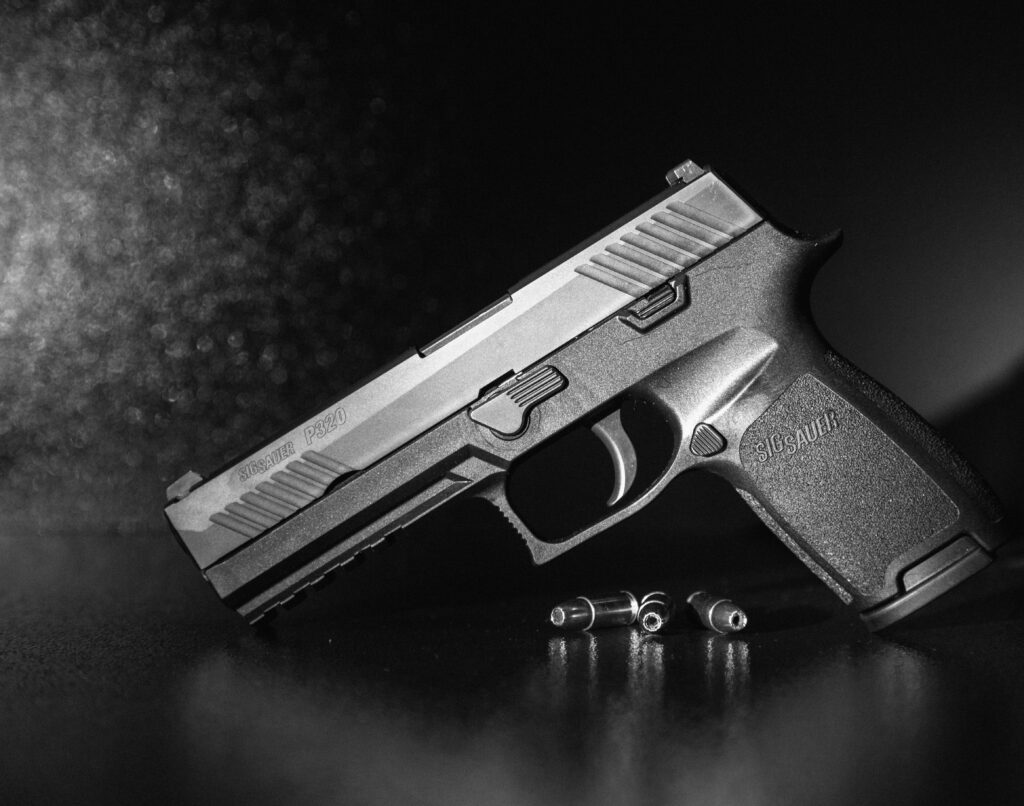 The Sig Sauer P320 pistol in 9mm is shown against a dark baground.