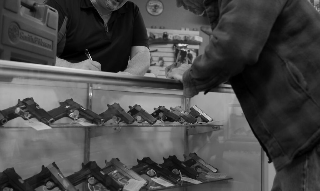 A man fills out paperwork to purchase a handgun at a gun shop. The NSSF allegedly built a database of customer data using warranty cards.