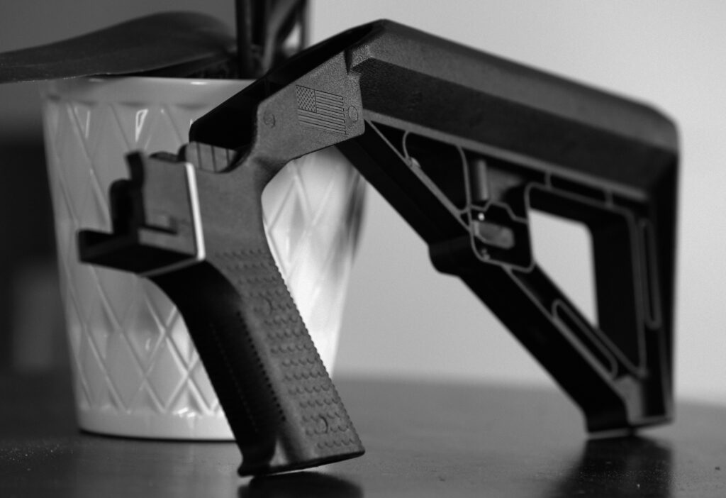 A Slide Fire bump stock designed for an AR-15 is shown resting on a table.