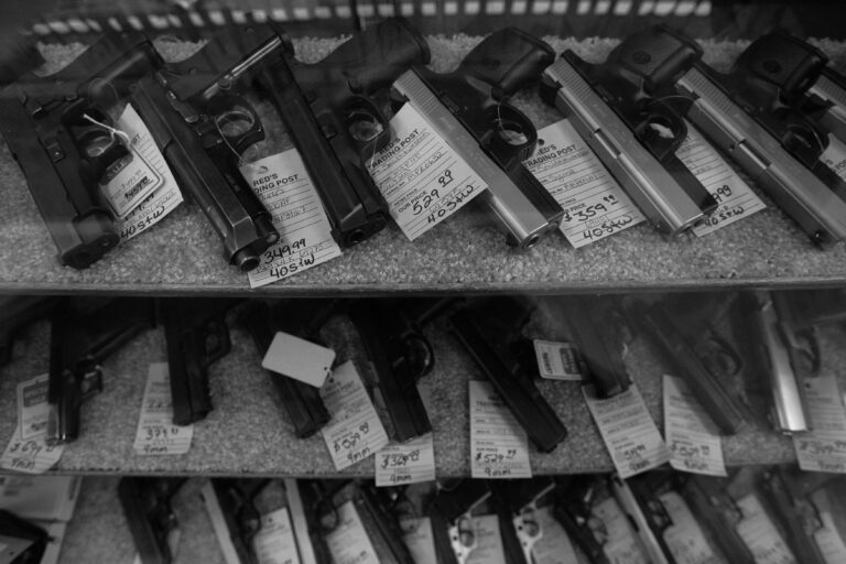 Pistols are shown in a display case at a gun shop as new changes at the ATF could mean fewer background checks on gun sales.