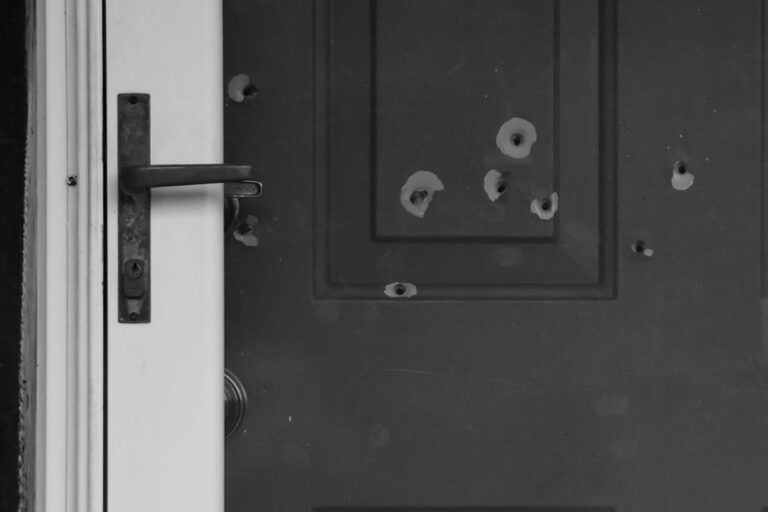 Bullet holes mark the front door of the house of Minnesota State Senator John Hoffman and his wife who were shot on June 14, 2025. The suspect allegedly used a Beretta pistol.