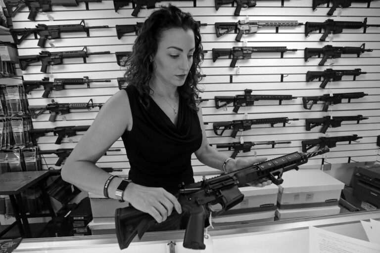A woman who sells guns in Washington holds an LWRCI AR-15.